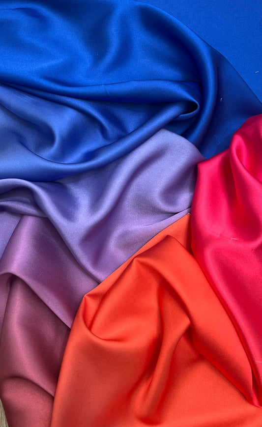 Detalle de transición de color ombré en seda satinada de azul a fucsia