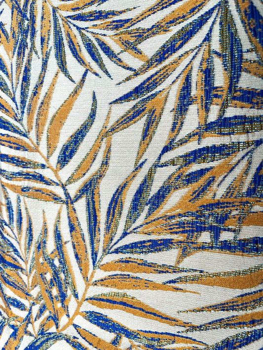 Detalle de hilo lurex metalizado en hojas de palma azul rey y dorado, jacquard tropical