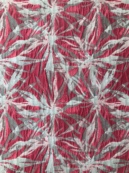 Primer plano de textura crinkle en jacquard coral, gris y blanco con doblez de tela