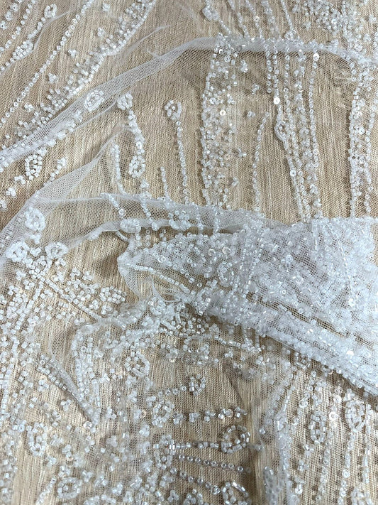 Detalle de bordado con lentejuela y canutillo en tul beige, diseño paisley